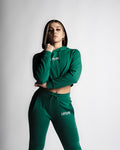 Woman standing confidently in full React Hoodie and Joggers set in green.