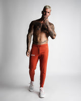 Front angle of athletic red joggers with minimalist design and logo. 