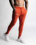 Athletic red joggers side profile showing sculpted tapered cut. 