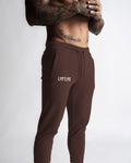 Zoomed detail of front right pocket and LYFTLYFE branding on the brown joggers. 