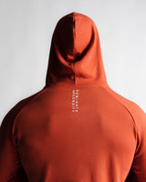 Close-up of “Dominate Adversity” slogan printed on red hoodie back seam.