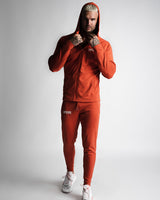 Full-body athletic look in Function hoodie and joggers zipped up in red. 