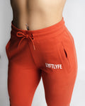  Close-up of red React joggers showing waistband, zipper pocket, and LYFTLYFE logo. 