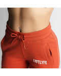  Close-up of React joggers in red showing waistband, zipper pocket, and LYFTLYFE logo. 