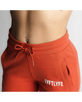  Close-up of React joggers in red showing waistband, zipper pocket, and LYFTLYFE logo. 