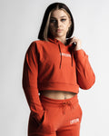 Woman wearing red cropped LYFTLYFE hoodie with drawstring, front-facing pose.