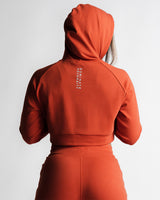 Back view of red hoodie showing 'Dominate Adversity' slogan vertically down the spine.