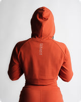 Zoom-in on 'Dominate Adversity' slogan printed on back of red hoodie.