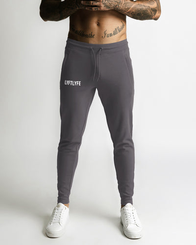 Charcoal grey sweatpants with 'LYFTLYFE' logo on a light gray background