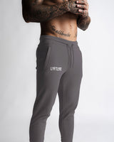 Close-up of LYFTLYFE logo and waistband on grey Function joggers.