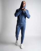 Full-body athletic look in Function hoodie and joggers zipped up in blue. 