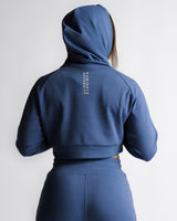 Back view of women's steel blue hoodie showing 'Dominate Adversity' slogan vertically down the spine.