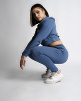 React joggers styled with cropped hoodie in blue, showcasing side profile. 