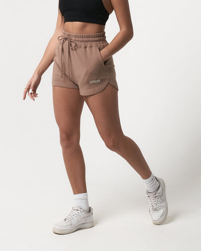 Women’s lightweight taupe sweat shorts with a flattering high-waisted fit and tonal drawstring for size customization.