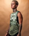Women’s sleeveless gym tank in green camo, displayed from the left side, highlighting its curved hem and durable triple-blend fabric.