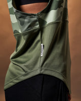 Detailed shot of the ‘Dominate Adversity’ flag tag on the side of the green camo sleeveless shirt.
