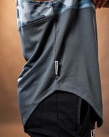 Close-up of the Dominate Adversity tag on the side hem of the Men’s Command Sleeveless Hoodie in blue camo.