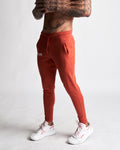 Left side view of men’s Function joggers in red with hidden zipper pocket detail. 