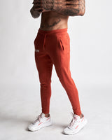 Left side view of men’s Function joggers in red with hidden zipper pocket detail. 