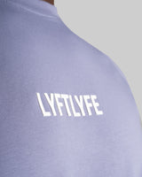 Close-up of the 3D rubberized LYFTLYFE logo on the chest of the Contour Men’s T-Shirt in purple, adding a premium touch.