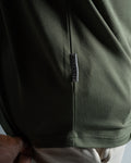 Close-up of the Dominate Adversity tag on the Contour Tee in green, highlighting premium craftsmanship and branding.
