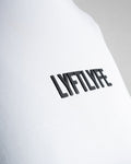 Close-up of the Lyftlyfe 3D rubberized logo on the chest of the white Drill Women’s Crop Tee, showcasing premium branding.