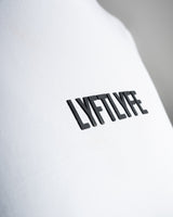 Close-up of the black Lyftlyfe logo on the white Contour Women’s Oversized Tee, crafted with precision and high-quality materials.