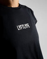 Close-up of the Lyftlyfe 3D rubberized logo on the chest of the black Drill Women’s Crop Tee, showcasing premium branding.