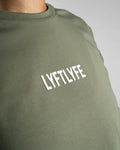 Close-up of the Lyftlyfe 3D rubberized logo on the chest of the olive green Drill Women’s Crop Tee, showcasing premium branding.