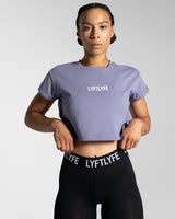 Drill Women’s Crop T-shirt in purple, showcasing its fitted cut, soft-stretch fabric, and moisture-wicking properties.