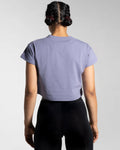 Women’s cropped Drill Tee in purple, displayed from the back, featuring a soft crew neckline and premium cover-stitching.