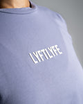 Close-up of the Lyftlyfe logo on the Contour Women’s Oversized Tee in purple, crafted with precision and high-quality materials.