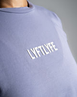 Close-up of the Lyftlyfe logo on the Contour Women’s Oversized Tee in purple, crafted with precision and high-quality materials.