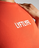 Close-up of the Lyftlyfe 3D rubberized logo on the chest of the red Drill Women’s Crop Tee, showcasing premium branding.