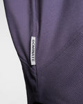 Close-up of Dominate Adversity side tag on Men’s Dominance Cut Sleeve in purple, stitched for lasting durability.