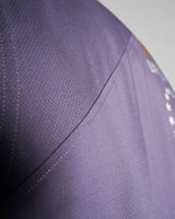 Close-up of reinforced seams and stretchable tri-blend fabric on purple sleeveless tank top. 