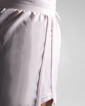 Close-up of side panel construction on light pink HIIT shorts with high-cut hem.