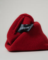 Detail of black LYFTLYFE fabric tag stitched inside maroon beanie.