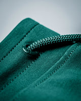 Green joggers showing precise drawstring cap detail and hem. 