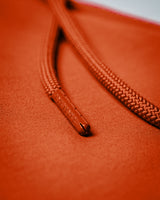 Custom LYFTLYFE drawstring caps on the red  Function joggers in close-up view. 