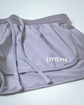 Embossed LYFTLYFE branding detail on purple performance shorts.
