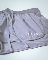 Embossed LYFTLYFE branding detail on purple performance shorts.
