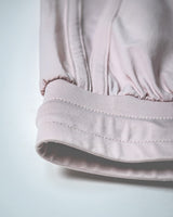 Close-up of stretch waistband of women's gym shorts in light pink. 