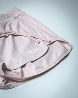 3D rubberized LYFTLYFE logo close-up on athletic shorts in light pink. 