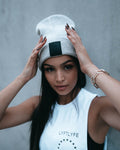 Female model wearing grey LYFTLYFE beanie with rubberized logo and white gym top.