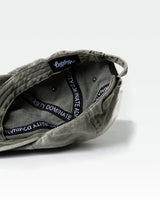 Detailed interior shot of green dad hat with Dominate Adversity taping and tag.