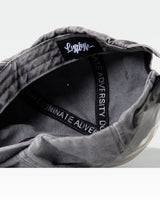 Detailed interior shot of grey dad hat with Dominate Adversity taping and tag.