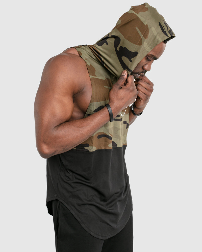Mens sleeveless hoodie made with two panels. The top panel is camo, including the hood. The bottom panel is black. 