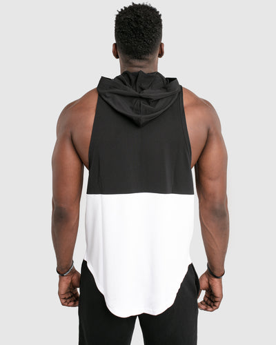 A Mens sleeveless tank top with a hood. Made with two panels - black on the top and white on the bottom with a black hood.